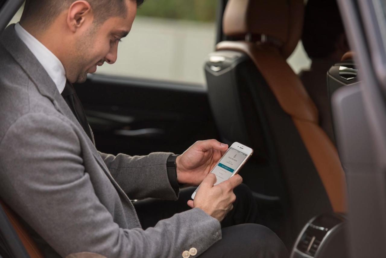 Four Seasons Hotel Rijad Zewnętrze zdjęcie A man using the Uber app